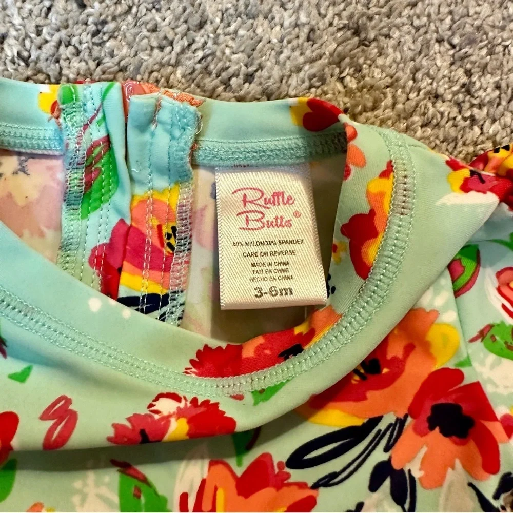 RuffleButts Painted Flowers One Piece Rash Guard Swimsuit